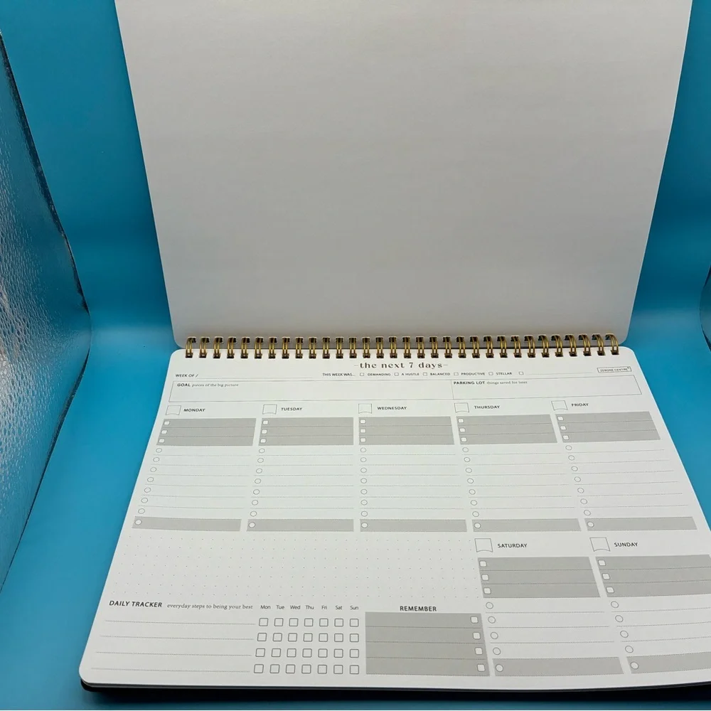 Zerone Productivity weekly planner featuring a gold spiral binding.